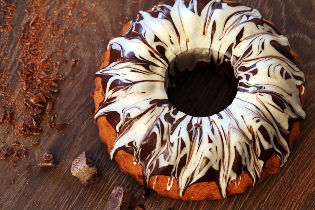 A delicious Bundt cake with chocolate on a wooden table