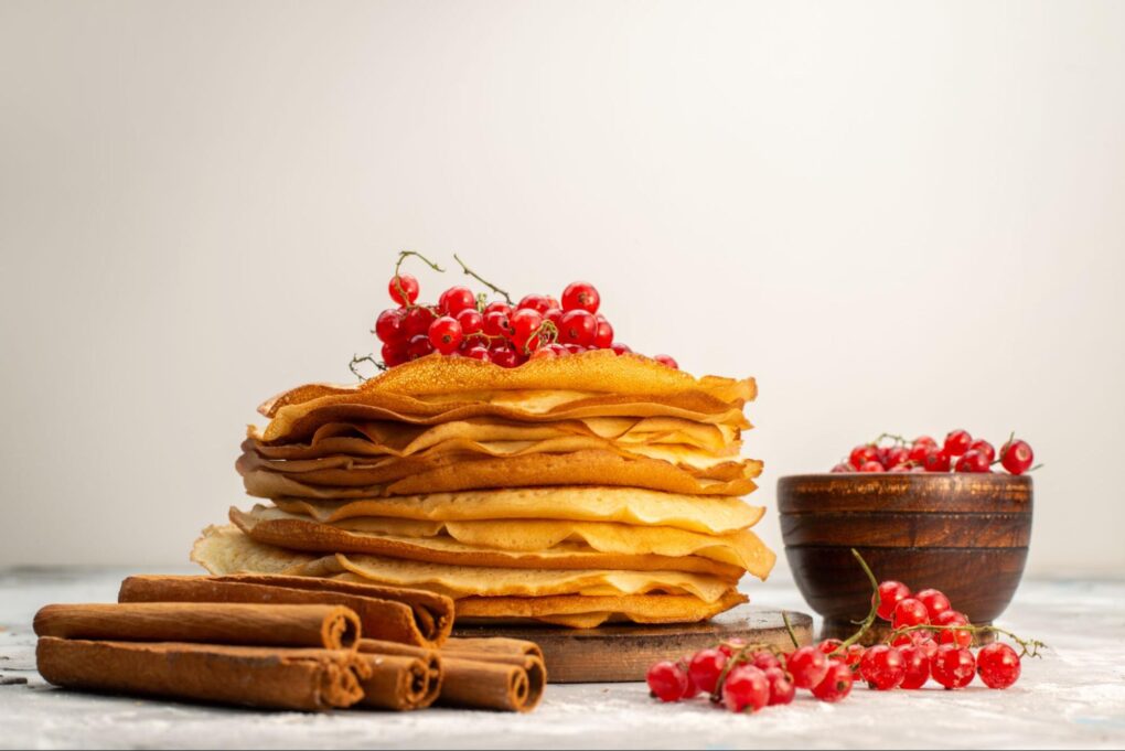 a front view of delicious round pancakes with cranberries and cinnamon